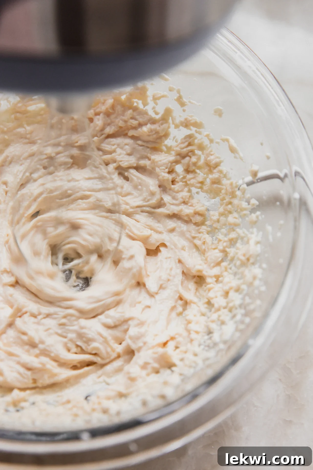 The dairy-free ricotta, powdered sugar, and vanilla extract being mixed with a hand mixer to create the cannoli cream.