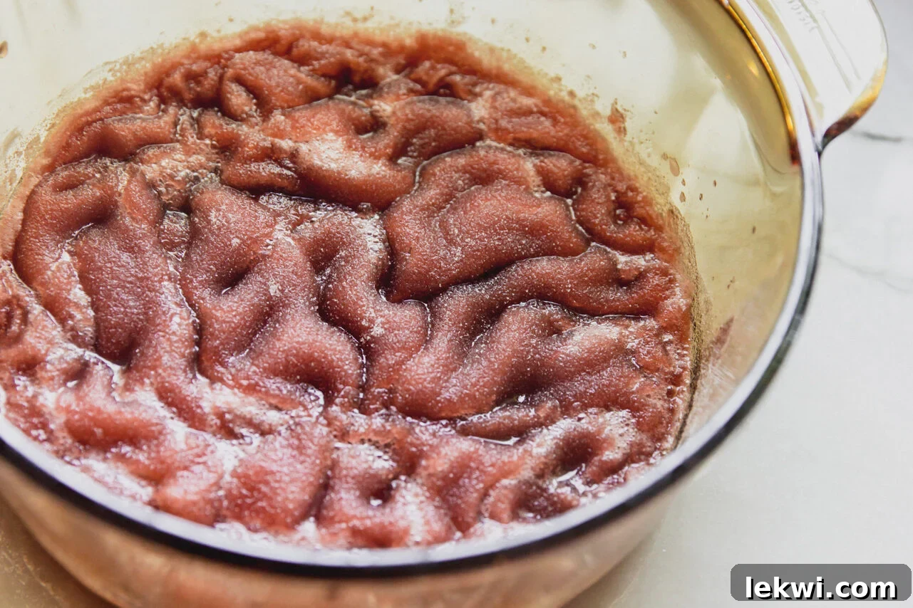 Cherry gummy liquid set with gelatin in a pot.