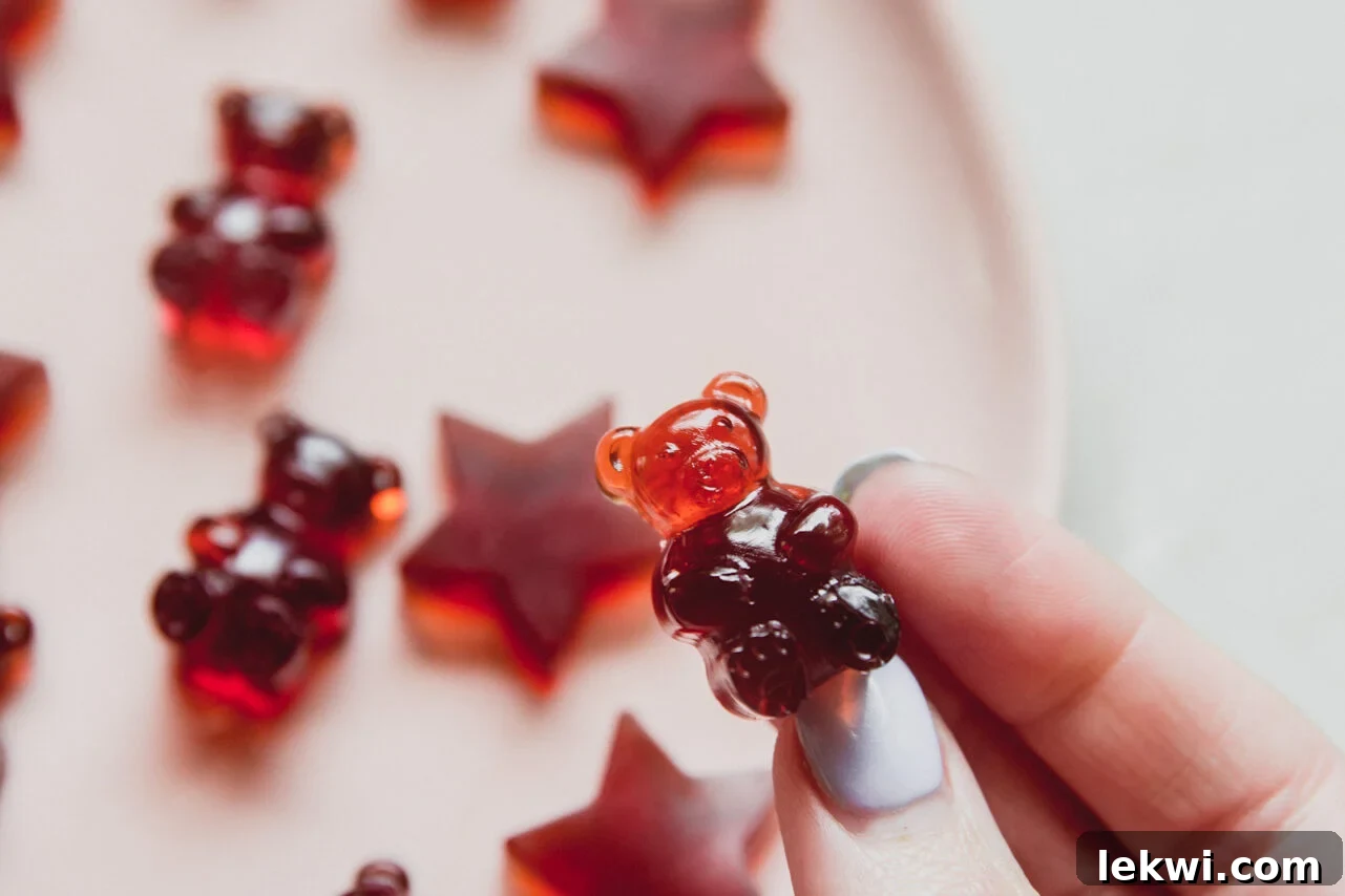 Cherry gummy bear being picked up.