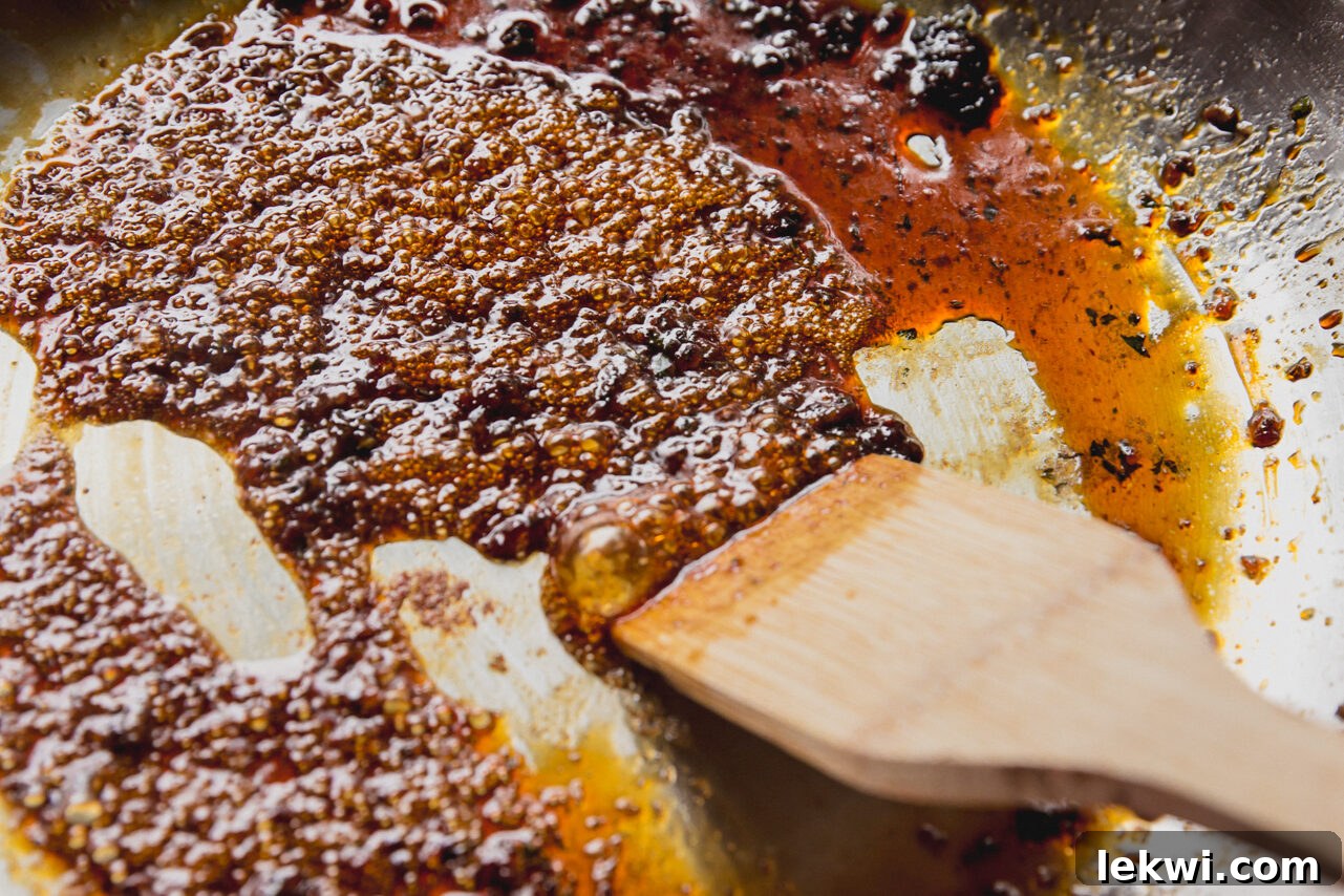 The pan being deglazed with coconut aminos, scraping up all the flavorful browned bits.