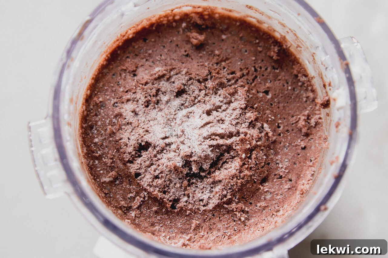 Chocolate protein ice cream frozen in a ninja creami container, before blending.