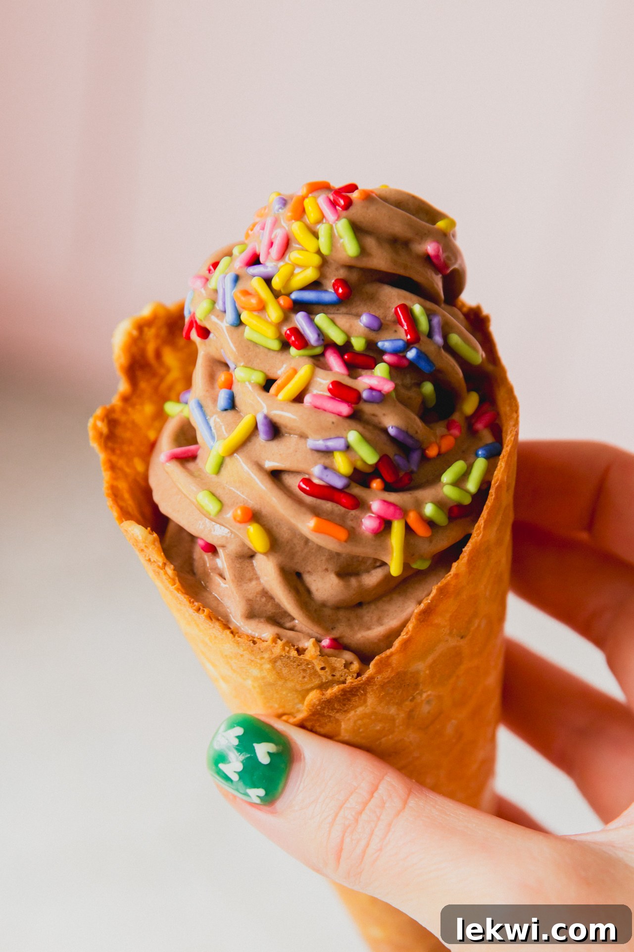 Dairy Free Ninja Creami protein ice cream in a cone topped with colorful sprinkles.