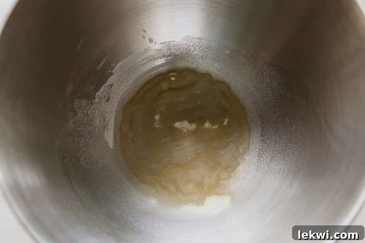 A stainless steel mixing bowl with gelatin and water setting. 