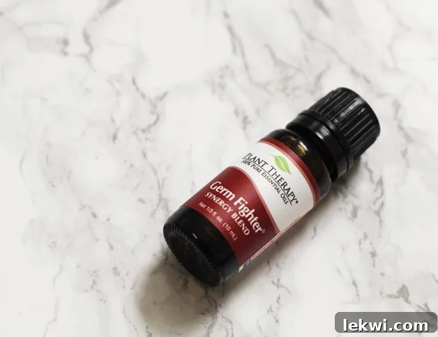 A small bottle of germ fighter blend lying on a counter.