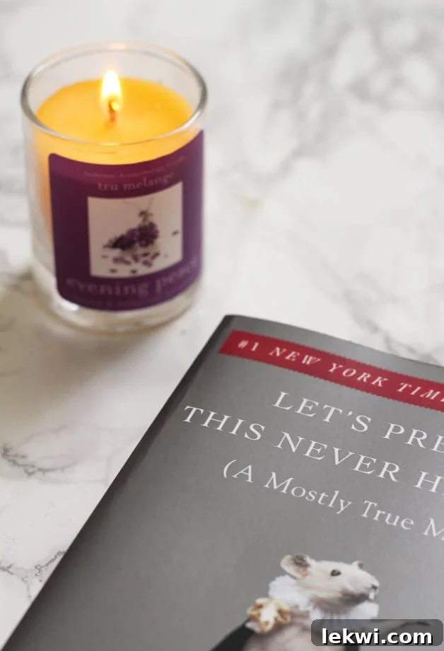 A candle and a book sitting out on a counter.