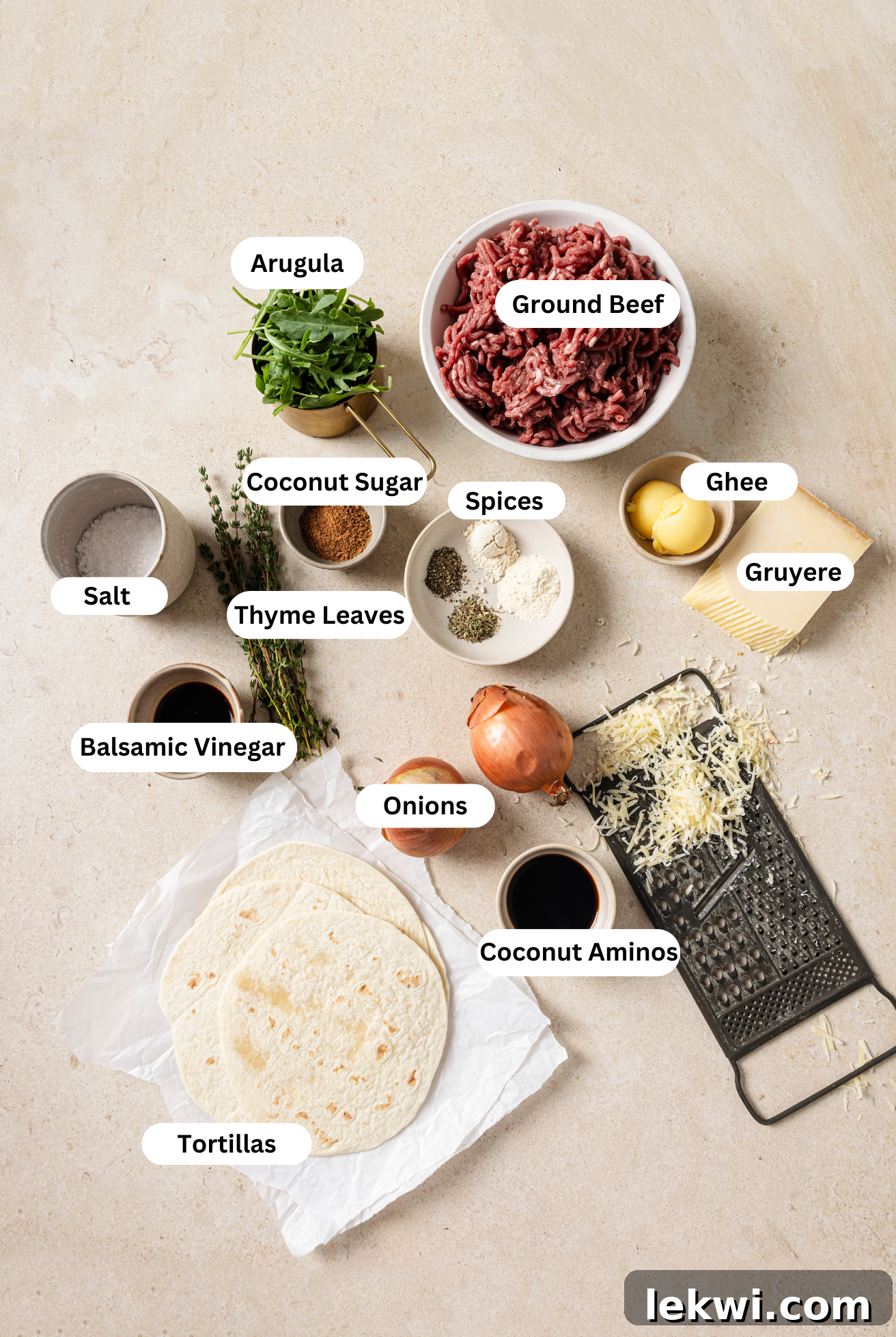All the fresh ingredients to make delicious French onion smashburger tacos neatly arranged on a counter.
