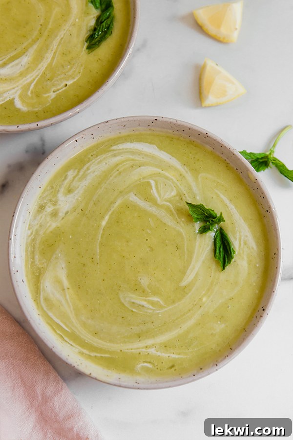 Top view of zucchini soup in a bowl topped with basil