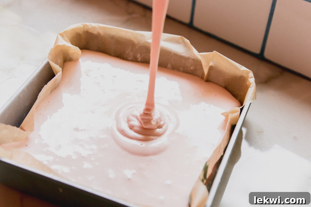 The pink layer being poured on top of the green layer before solidifying.
