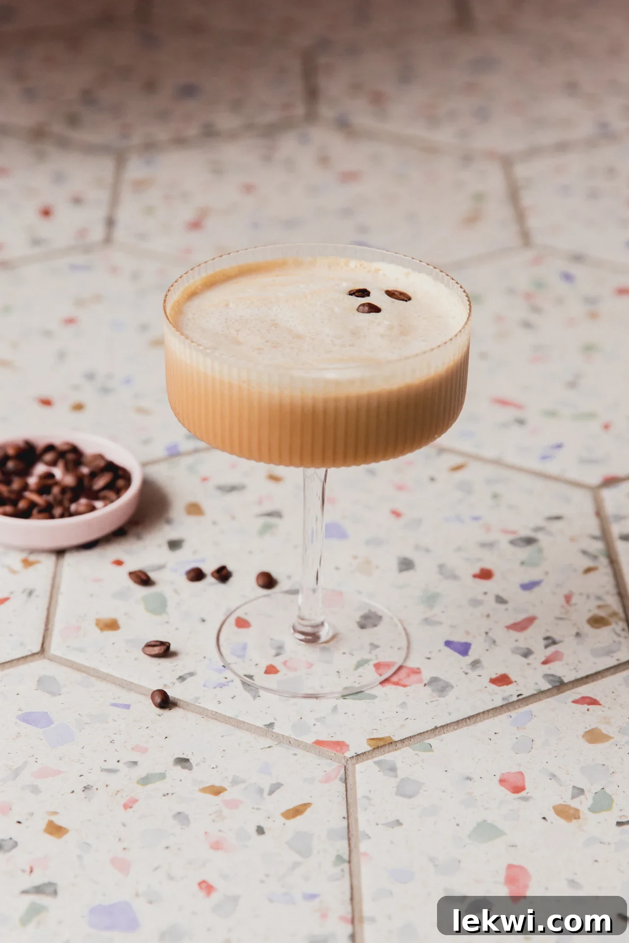 A beautifully garnished espresso martini mocktail topped with three espresso beans, presented in a classic martini glass.