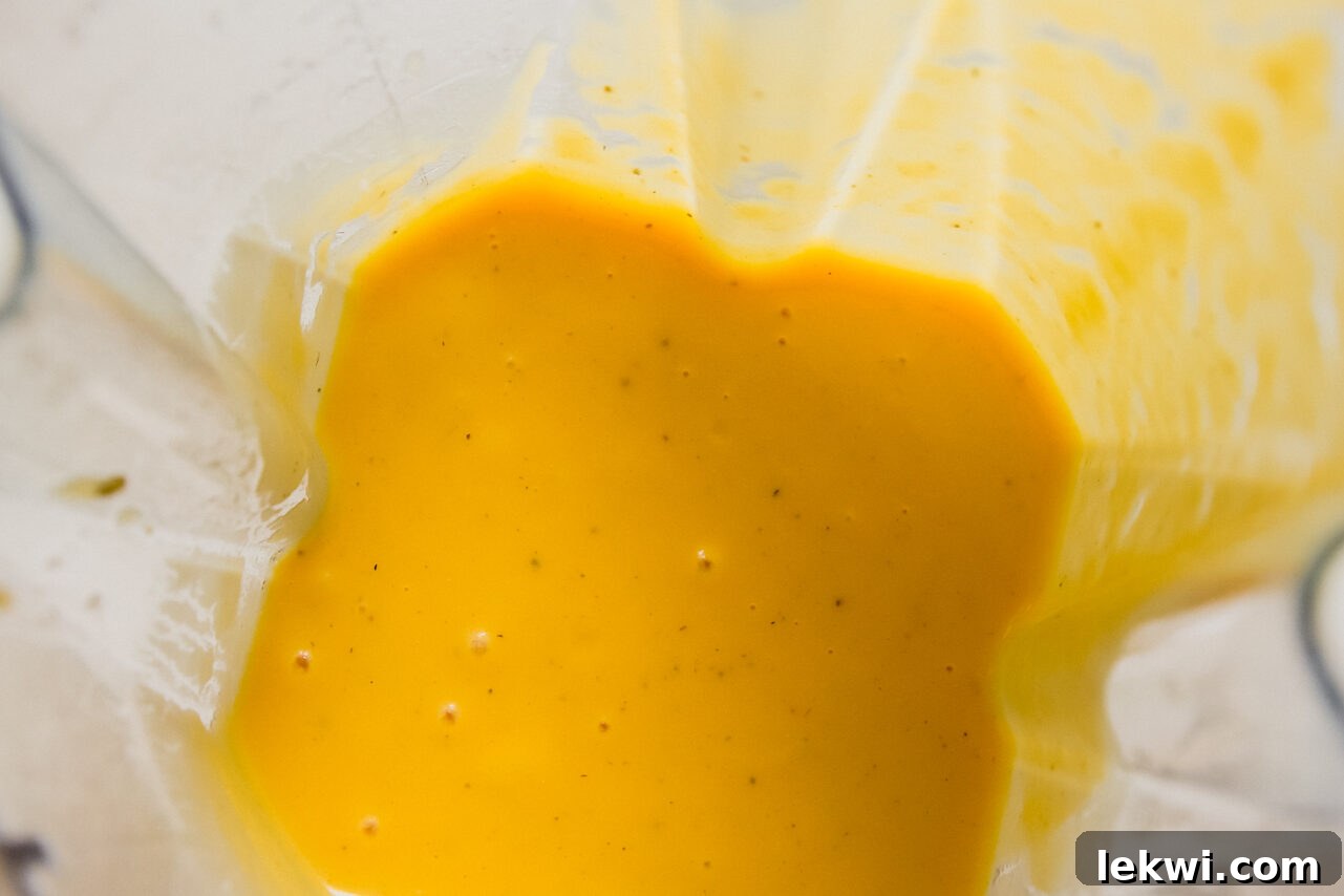 Creamy butternut squash sauce freshly blended in a blender, showcasing its smooth and vibrant texture.