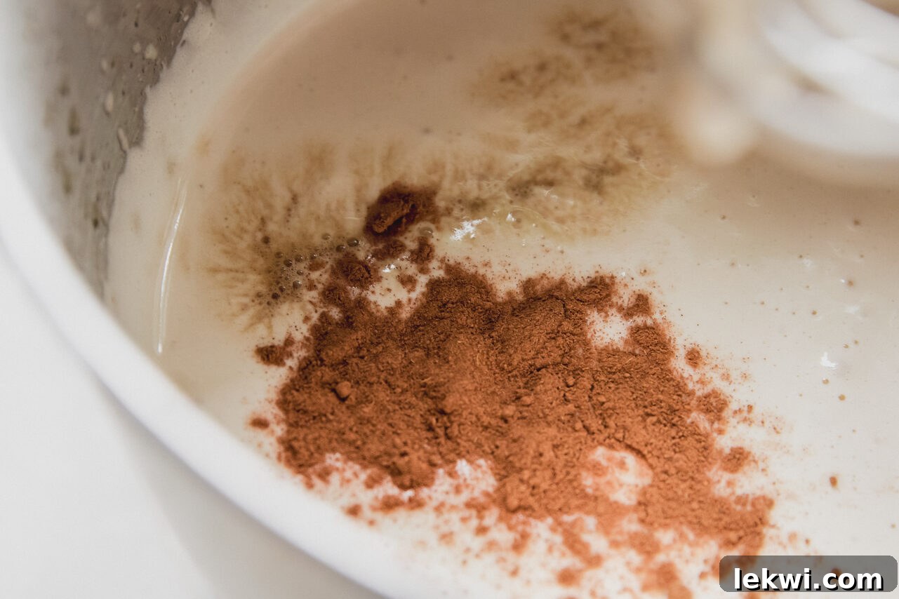 Pumpkin spice marshmallow fluff in a stand mixer with the pumpkin spice not mixed in. 