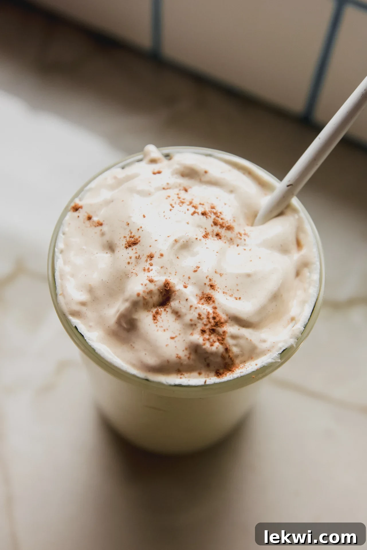 Pumpkin spice marshmallow fluff in a large glass jar topped with cinnamon.