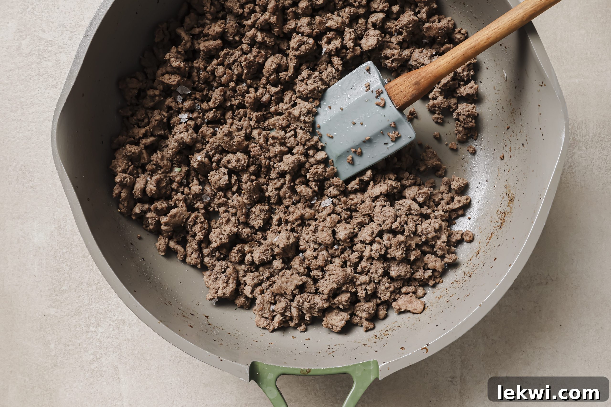 Cooked ground beef browned and crumbled in a large pan, ready for the next steps of the gravy.