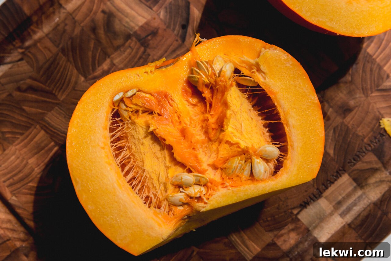 A sugar pumpkin neatly sliced in half, ready for deseeding.