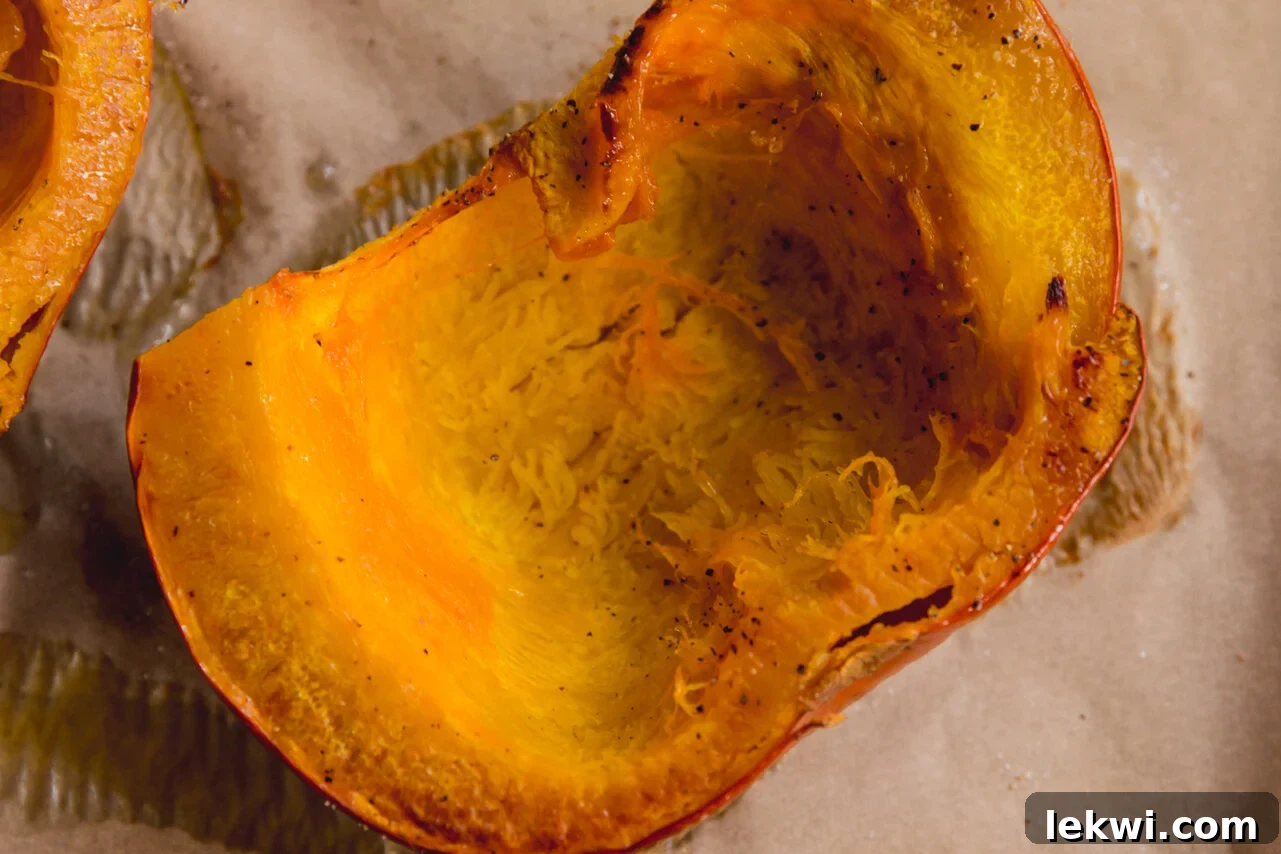 The roasted sugar pumpkin halves, beautifully caramelized after baking, cooling on a baking sheet.