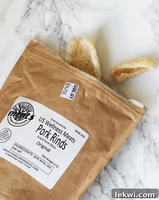 A package of pork rinds lying on the counter with a few pork rinds coming out.