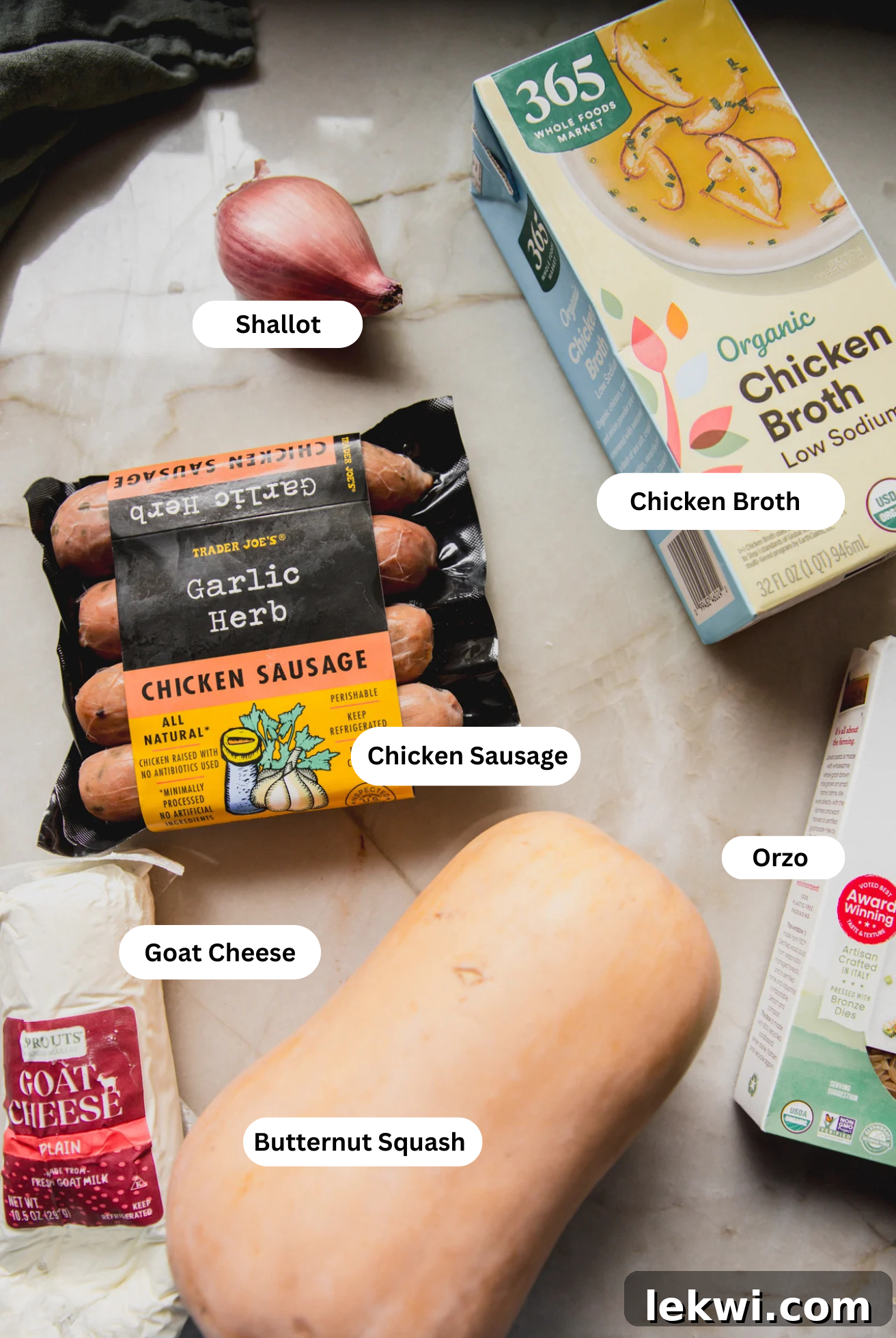 All the fresh ingredients for chicken sausage and orzo bake laid out on a table.