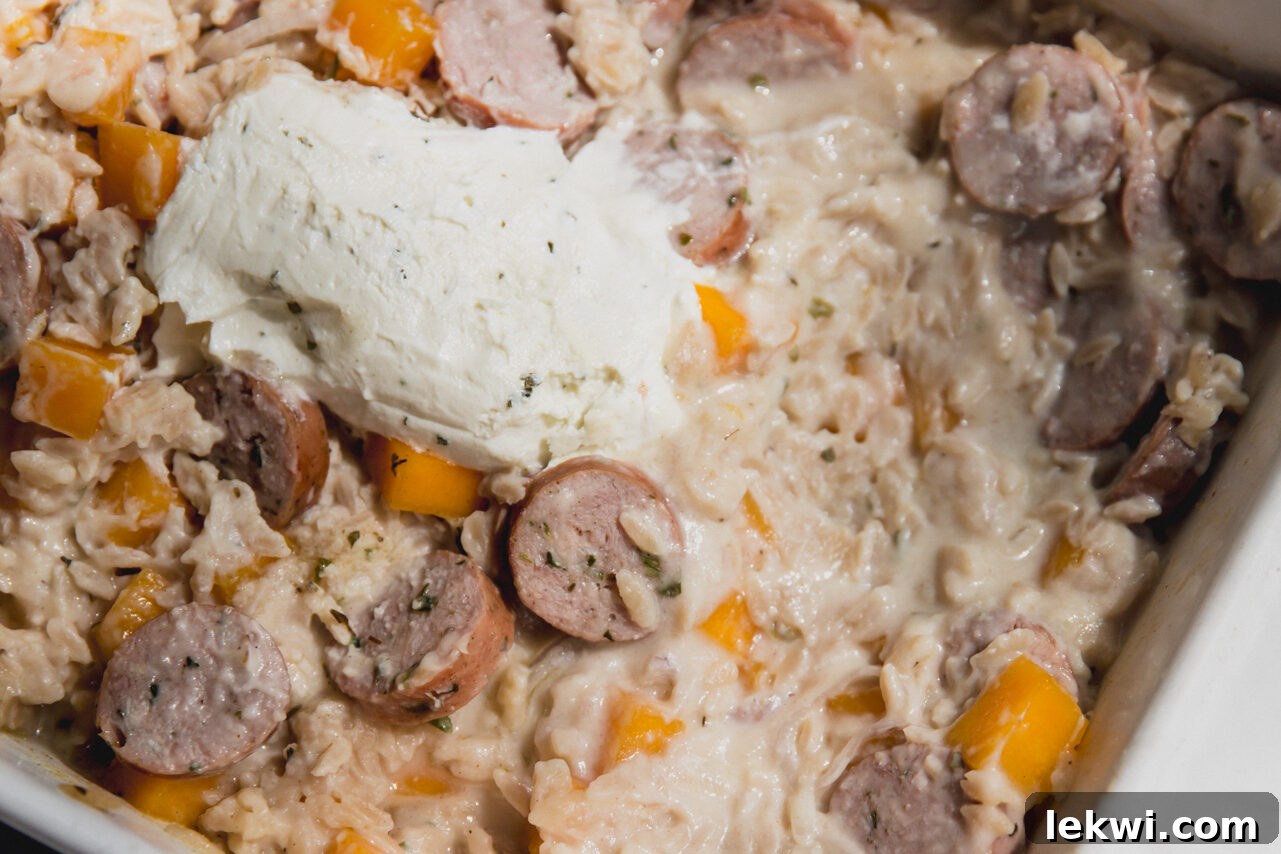 The chicken sausage and orzo after baking, before being mixed to create a creamy sauce.