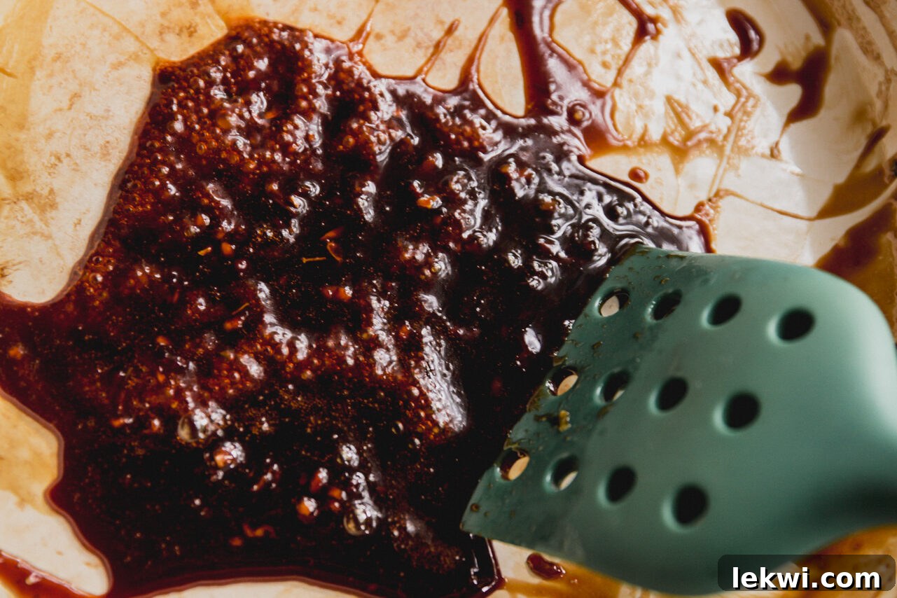 The orange glaze bubbling gently in a pan, thickening as it reduces, creating a luscious sauce.