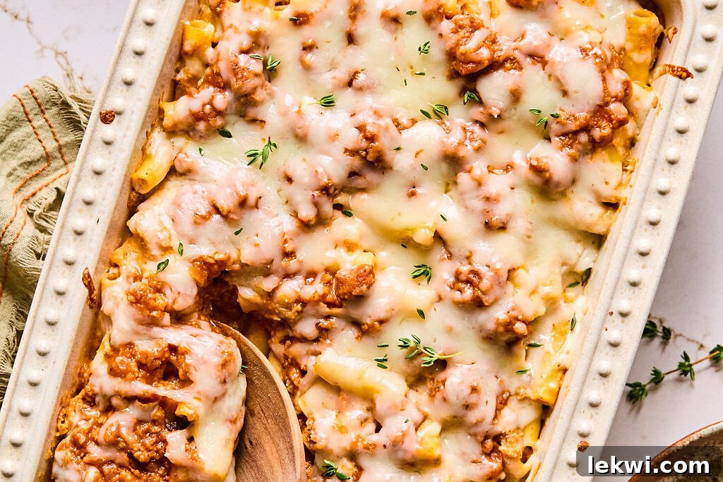 The finished butternut squash baked ziti, bubbling and golden-brown, garnished with fresh thyme, ready to be served.