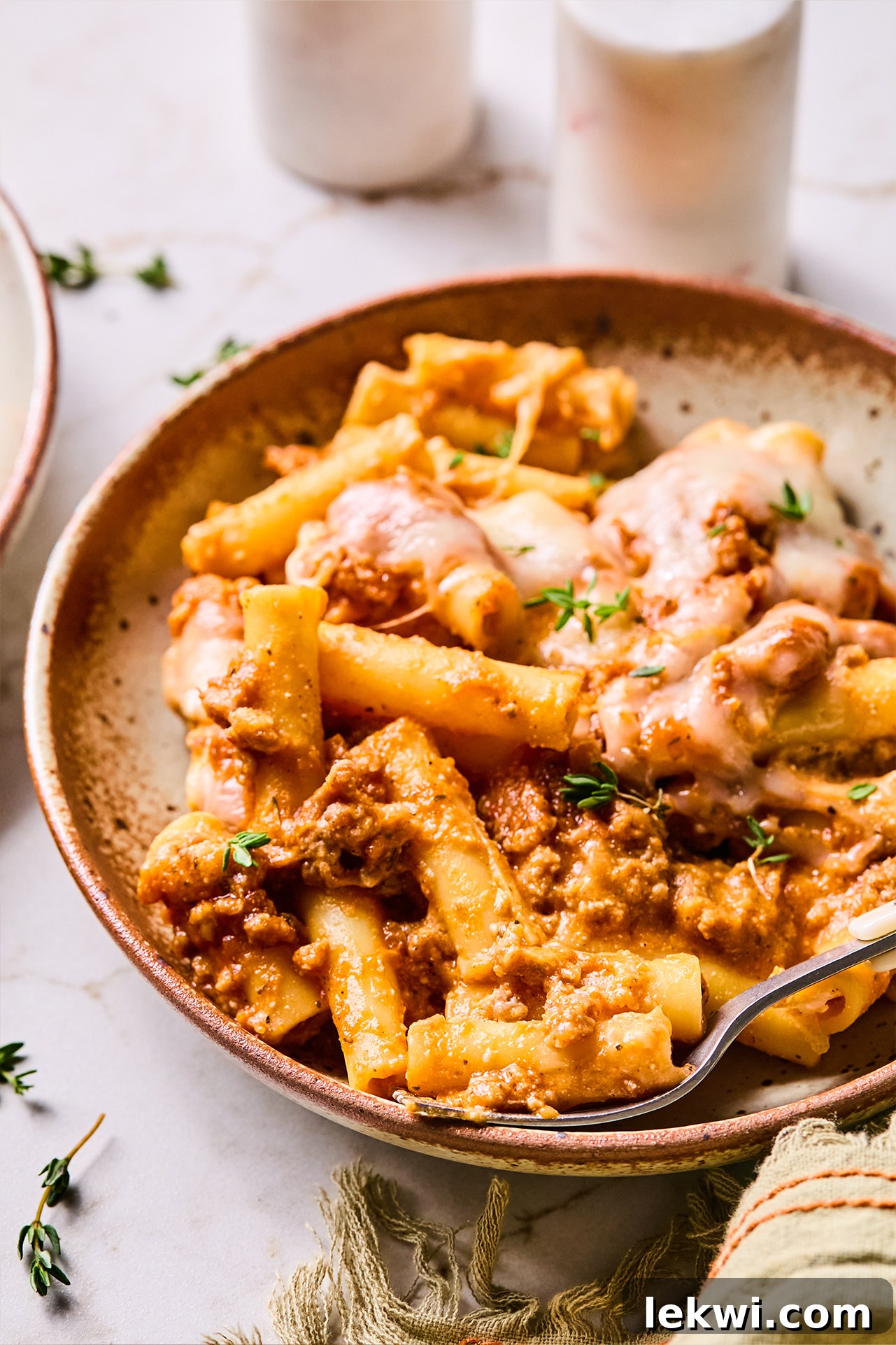A serving of butternut baked ziti on a plate, with a fork ready to enjoy the hearty and comforting meal.