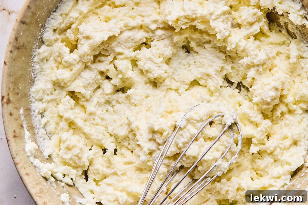 A bowl containing a creamy mixture of ricotta, pecorino, and shredded mozzarella cheeses, ready for the pasta.