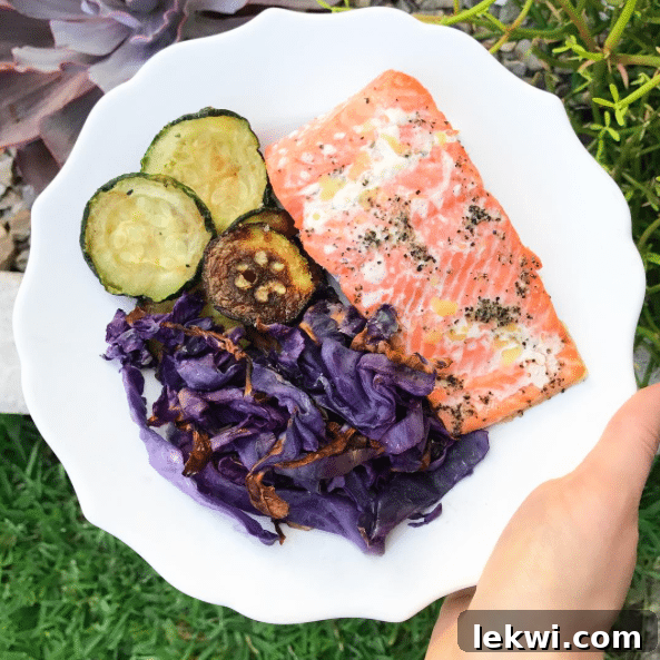 A plate with salmon, cabbage, and zucchini on it