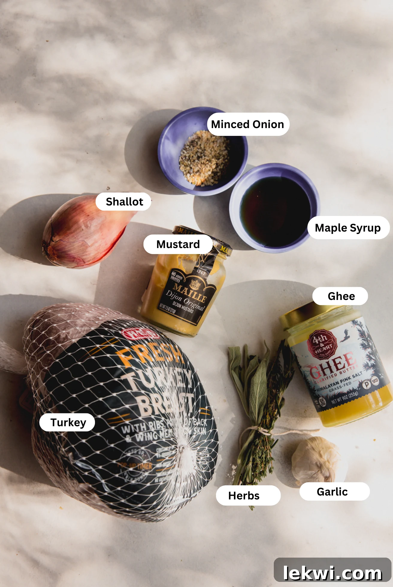 All the fresh and dry ingredients needed to make slow cooker maple dijon turkey breast laid out on a kitchen counter before cooking.