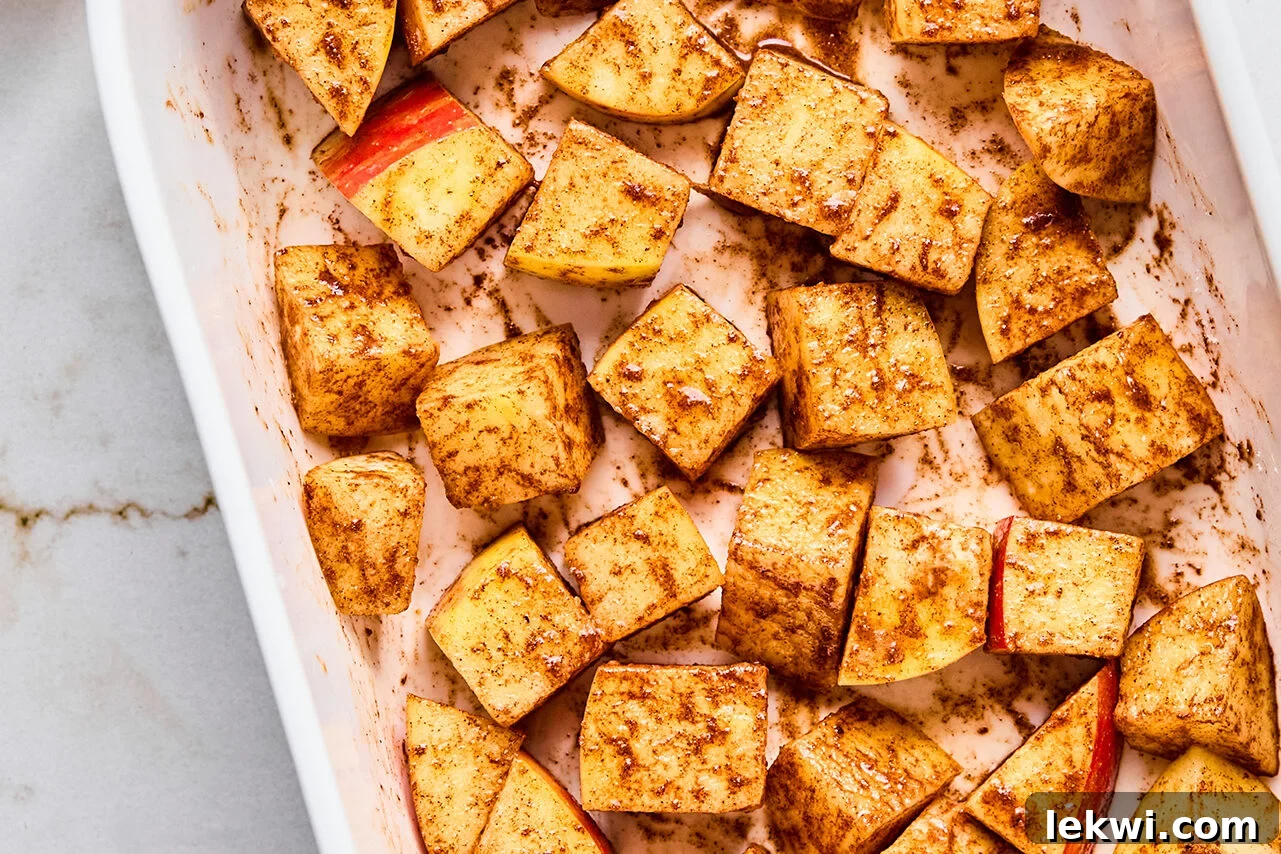 The diced apples in a baking sheet before anything is added to them.