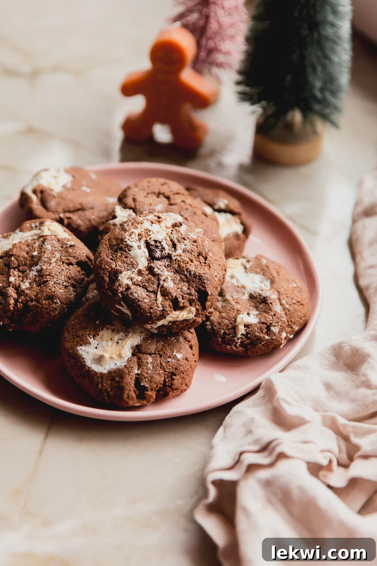 Pillowy soft gluten-free chocolate marshmallow fluff cookies on a pink plate with festive decorations in the background.