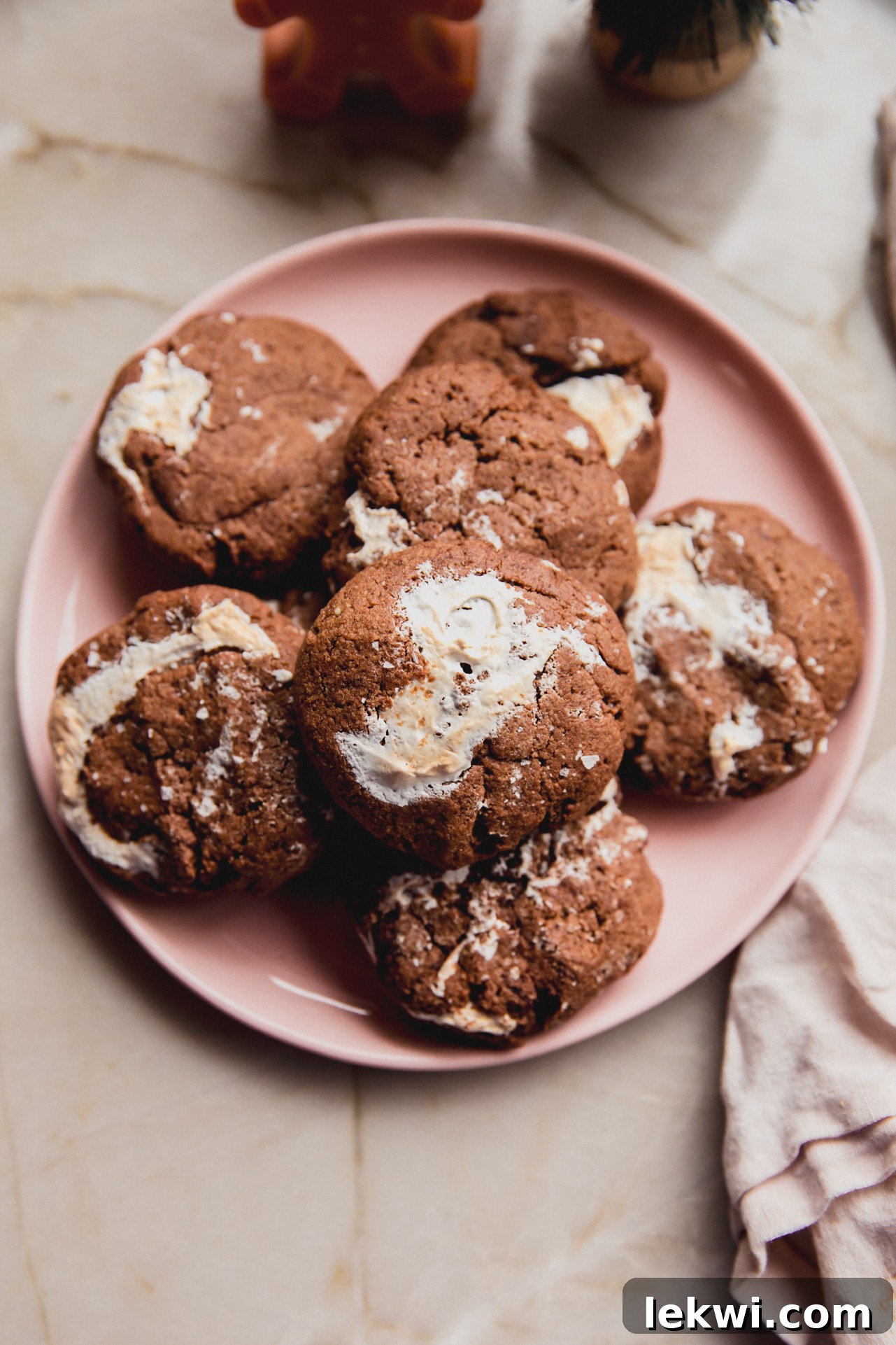 A festive stack of gluten-free chocolate marshmallow cookies on a pink plate, ready for a delicious holiday treat.