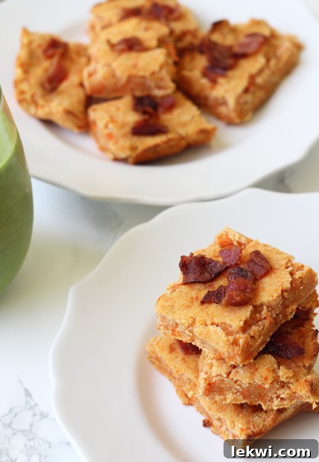 A stack of sweet potato bacon bars sitting on a rustic wooden plate, ready to be enjoyed as a healthy breakfast or snack.