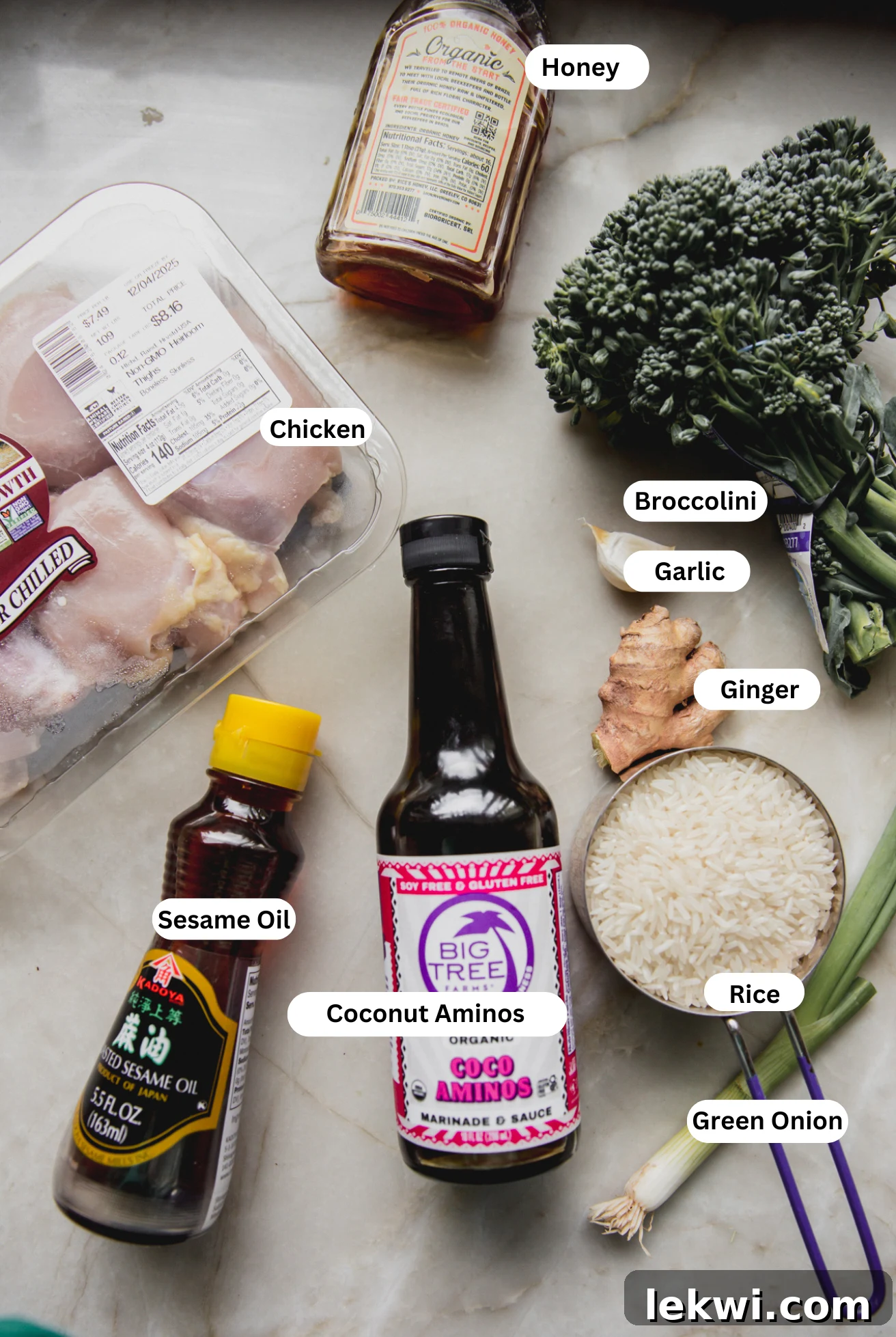A beautiful flat lay of all fresh ingredients for brothy ginger chicken and rice, neatly arranged before cooking, including chicken, ginger, garlic, vegetables, and rice.
