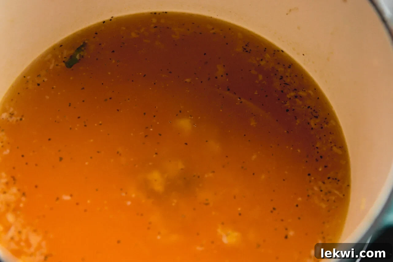A sturdy Dutch oven simmering a fragrant broth, steam gently rising, indicating the rich flavors developing within.