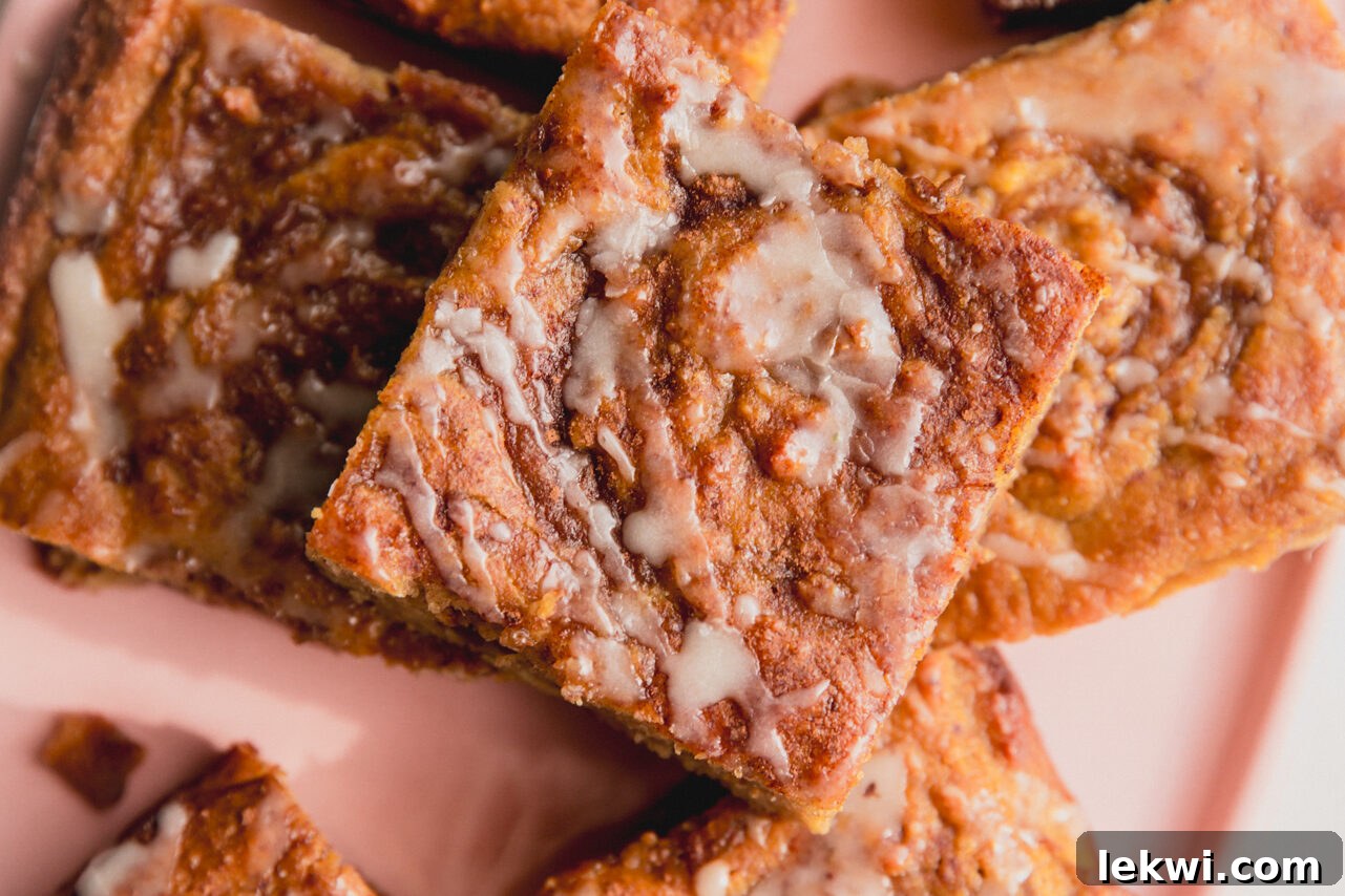 Perfectly baked slices of gluten-free cinnamon roll cake, glazed and arranged on a pink plate.