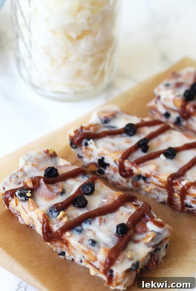 Three perfectly formed grain-free granola bars displayed on parchment paper, highlighting their delicious and healthy nature.