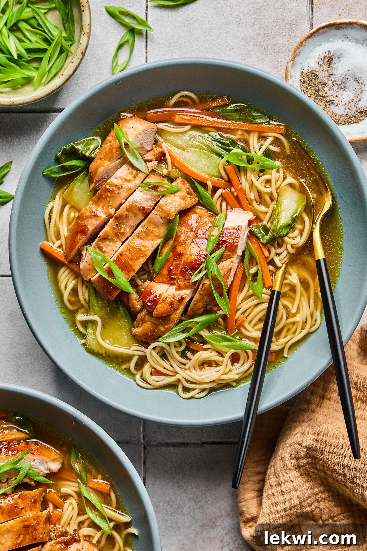 A vibrant bowl of Chicken Teriyaki Ramen, featuring slices of succulent chicken, green onions, and colorful vegetables, all nestled in a rich broth.