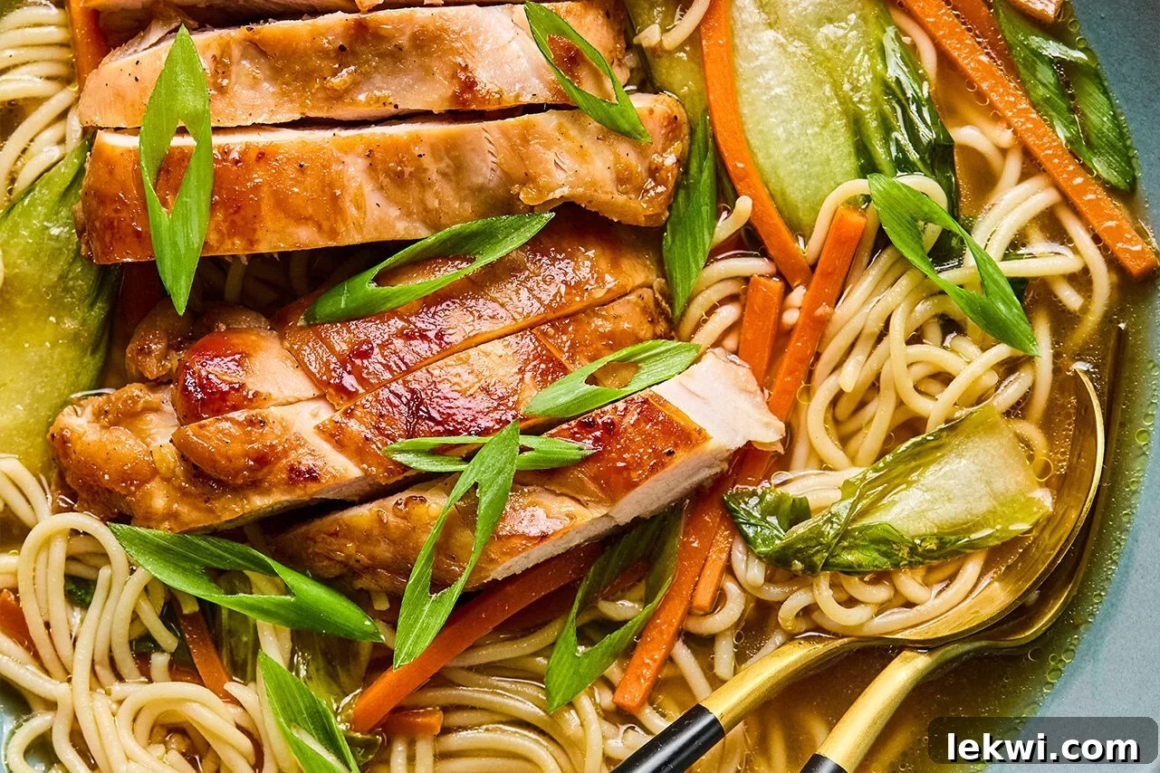 The final delicious dish of Chicken Teriyaki Ramen, elegantly plated with broth, noodles, vegetables, and sliced chicken, garnished with green onions.