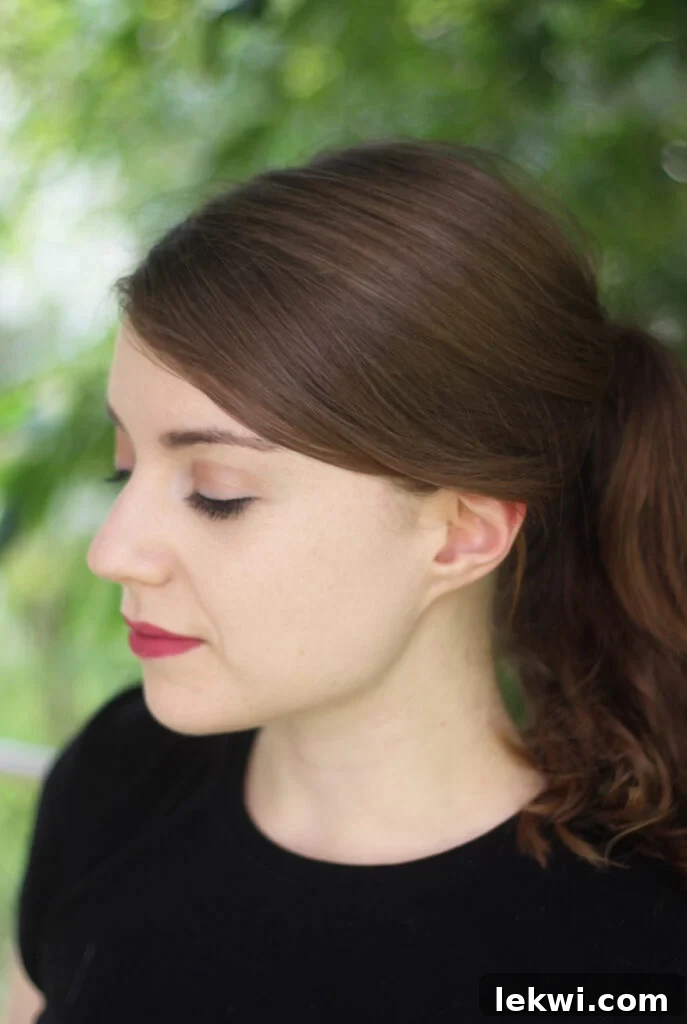 A photo of Michelle against a green background looking down.