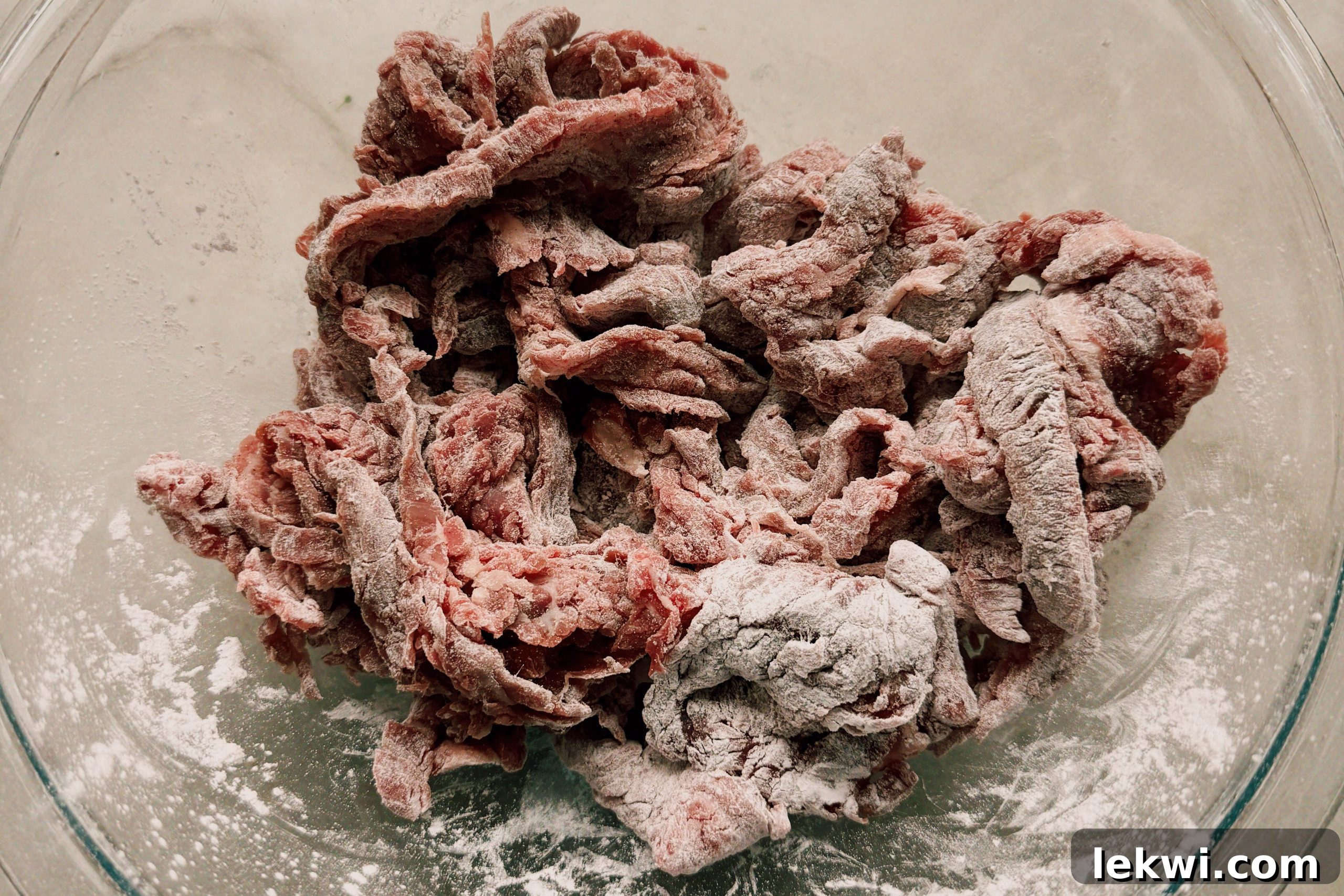 Wok-Tossed Gluten-Free Beef Noodles 5 A glass bowl with beef covered in arrowroot starch before cooking.