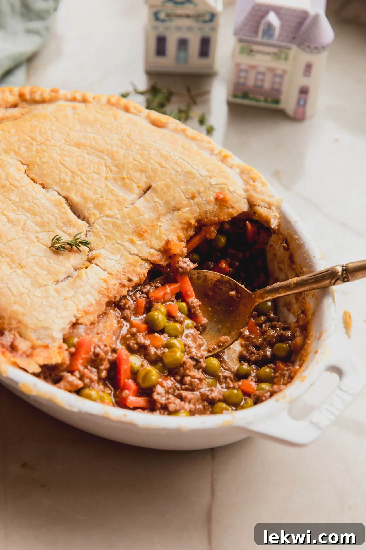 Comforting Gluten-Free Beef Pot Pie 10 Beef pot pie with a crust and meat filling in a casserole dish with a spoon, symbolizing homemade comfort.