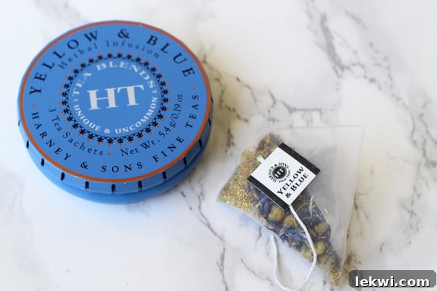 Bir fincan çayın yanında çay torbası bulunan bir çay kutusu.