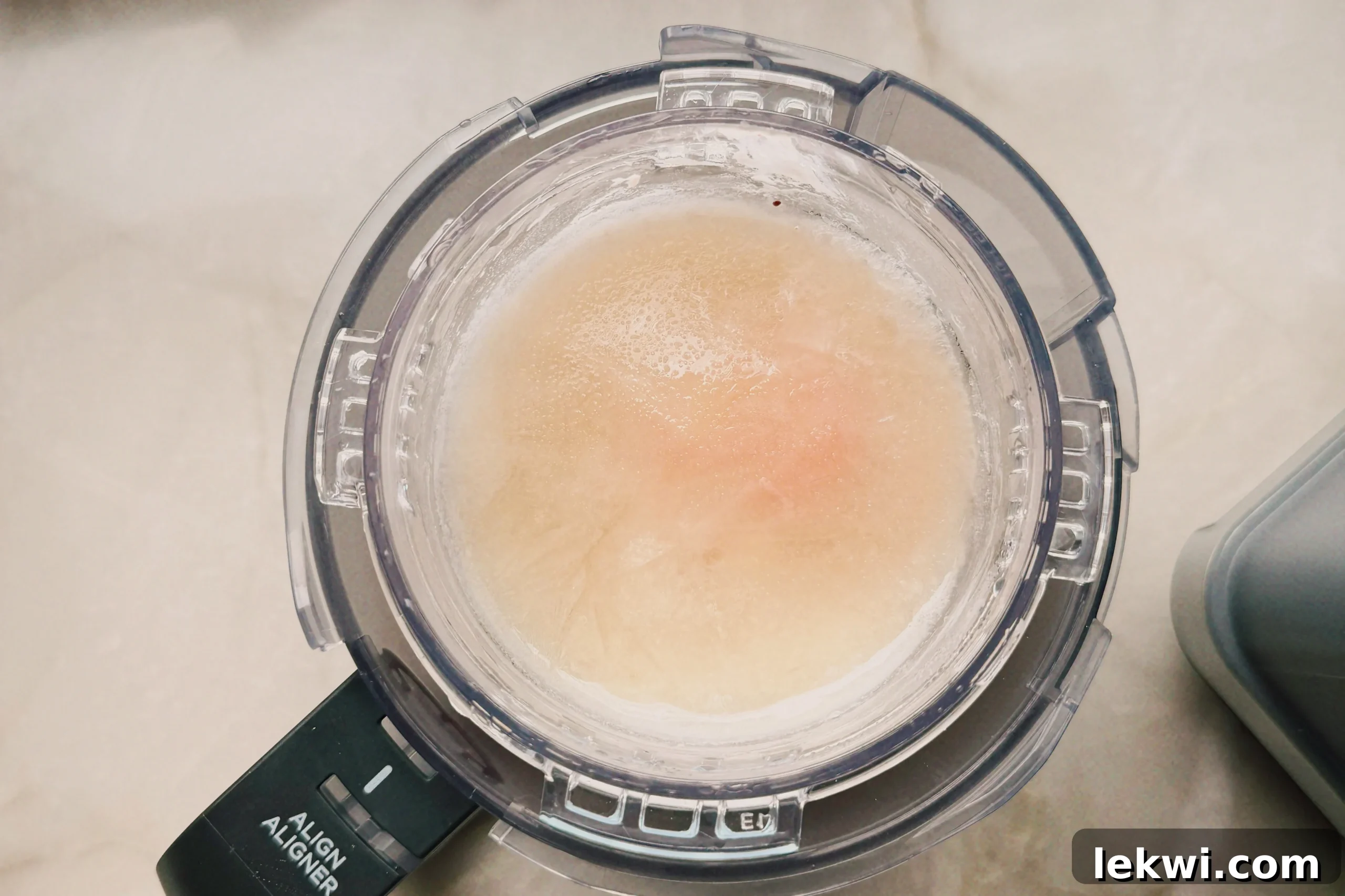 Ninja Creami Dairy Free Strawberry Ice Cream 5 A top-down view of the fully frozen strawberry Ninja Creami base in its pint container, showing a solid, uniform block of frozen fruit and dairy-free mixture, ready for processing.