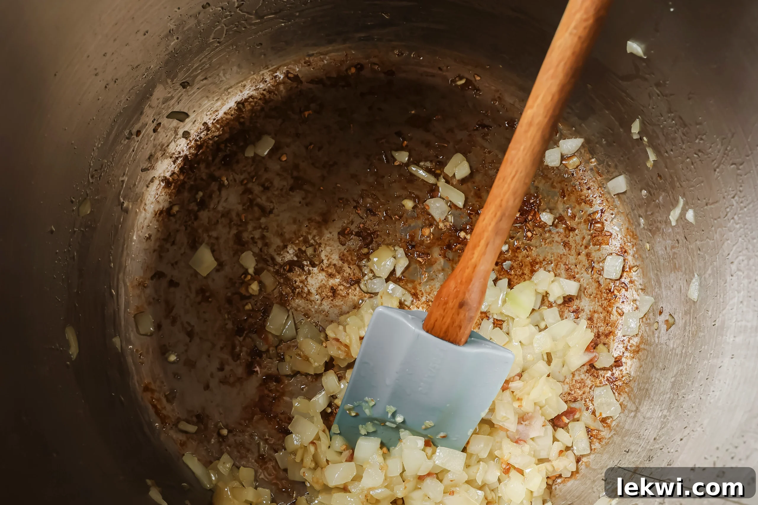Diced onion and minced garlic sautéing in bacon fat in the Instant Pot.