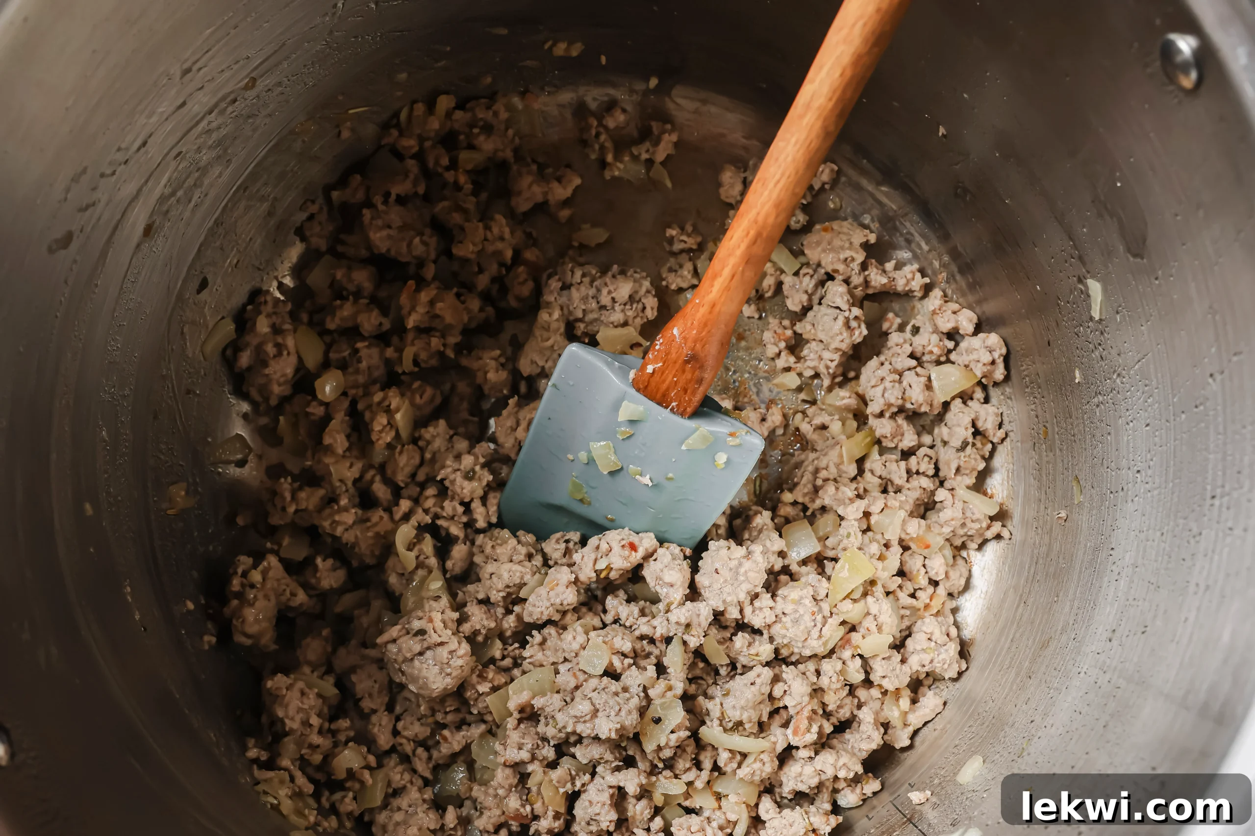 Ground Italian sausage browning in the Instant Pot after the aromatics.