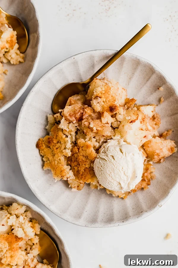 apple crisp on plate with spoon and ice cream