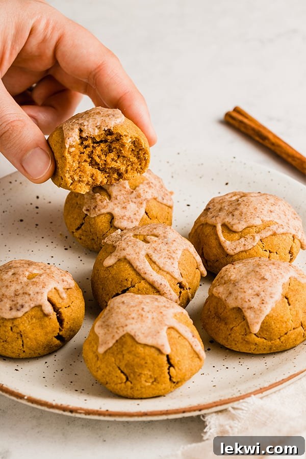 A hand grabbing a pumpkin pie donut bite off of a plate of pumpkin pie donut bites.