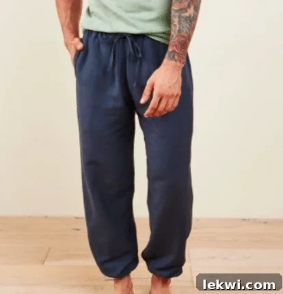 A man wearing navy blue joggers and a green shirt.