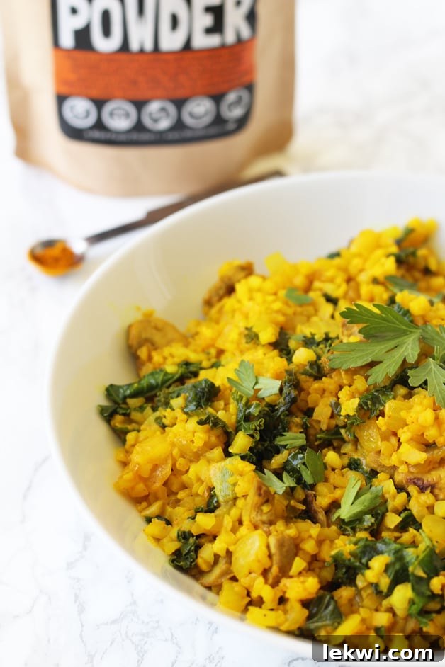 A bowl of turmeric cauliflower rissoto topped with herbs.