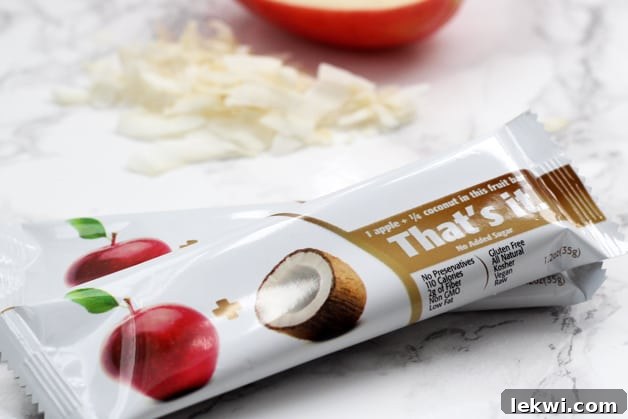 Two coconut apple That's Its bars on a counter.